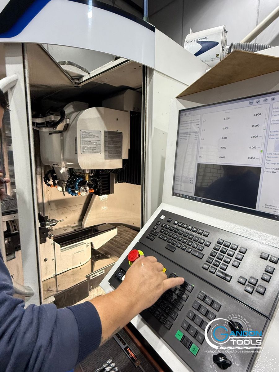 Operador em painel de controle de retificadora CNC